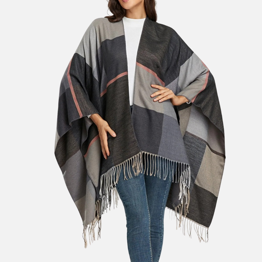 Femme portant cape poncho coton carreaux gris noir avec franges blanches ouvert devant