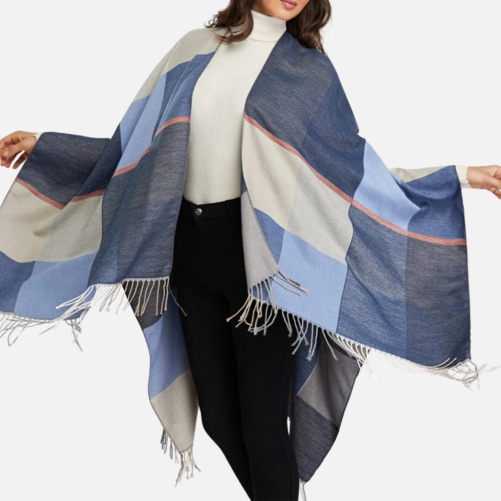 Femme portant une cape poncho en coton à carreaux bleus, beiges et gris avec franges