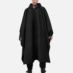 Cape poncho en coton noir avec capuche, coupe longue aux genoux, portée de face par un homme
