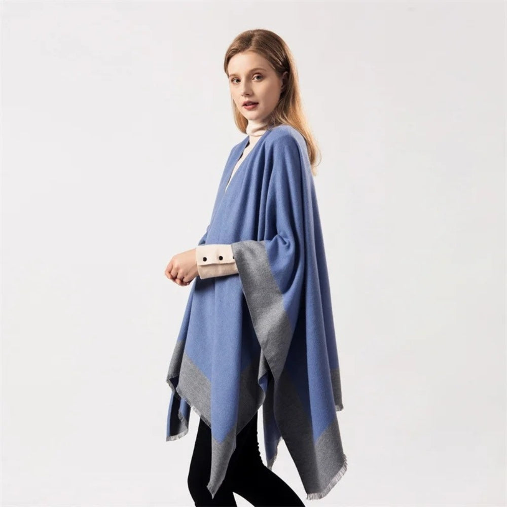 Femme portant une cape poncho bicolore bleu et gris avec franges et poche beige