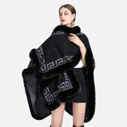 Femme portant cape poncho noire avec bordure fourrure et motif grec gris