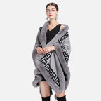 Femme portant cape poncho grise fourrure motif grec noir, vue de face