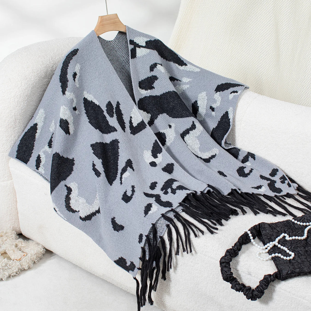 Cape poncho femme gris bleu motif léopard noir avec franges, présentée sur cintre