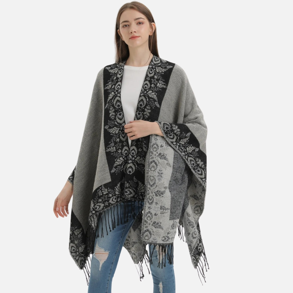 Cape poncho femme grise avec motifs floraux et franges, portée de face sur jeans bleu