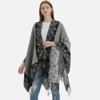 Cape poncho femme grise avec motifs floraux et franges, portée de face sur jeans bleu