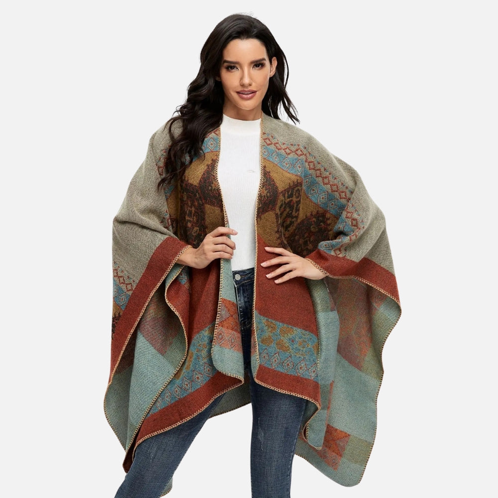 Femme portant cape poncho ethnique ouverte devant, motifs géométriques marron bleu rouge beige