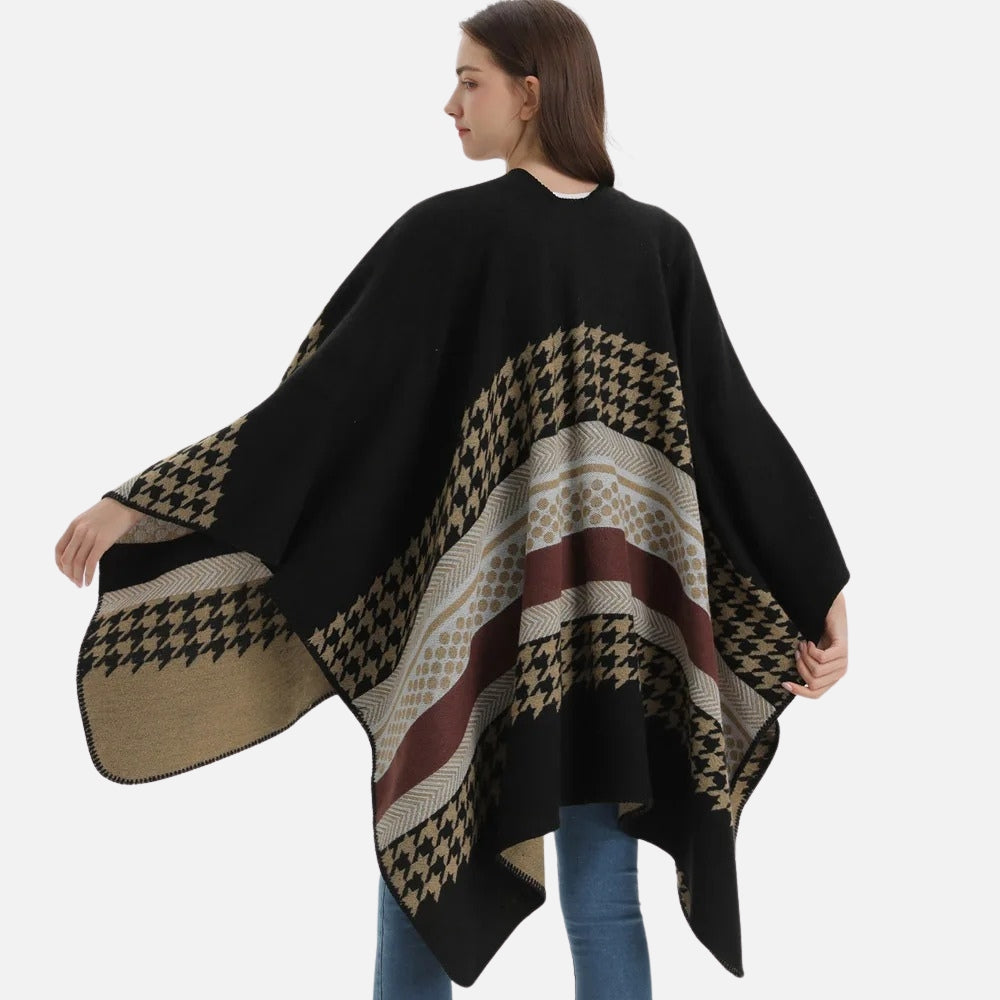 Femme portant une cape poncho noire et beige avec motifs pied-de-poule, vue de dos