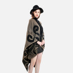 Femme portant cape poncho réversible taupe et noir avec motif arabesques, vue de profil