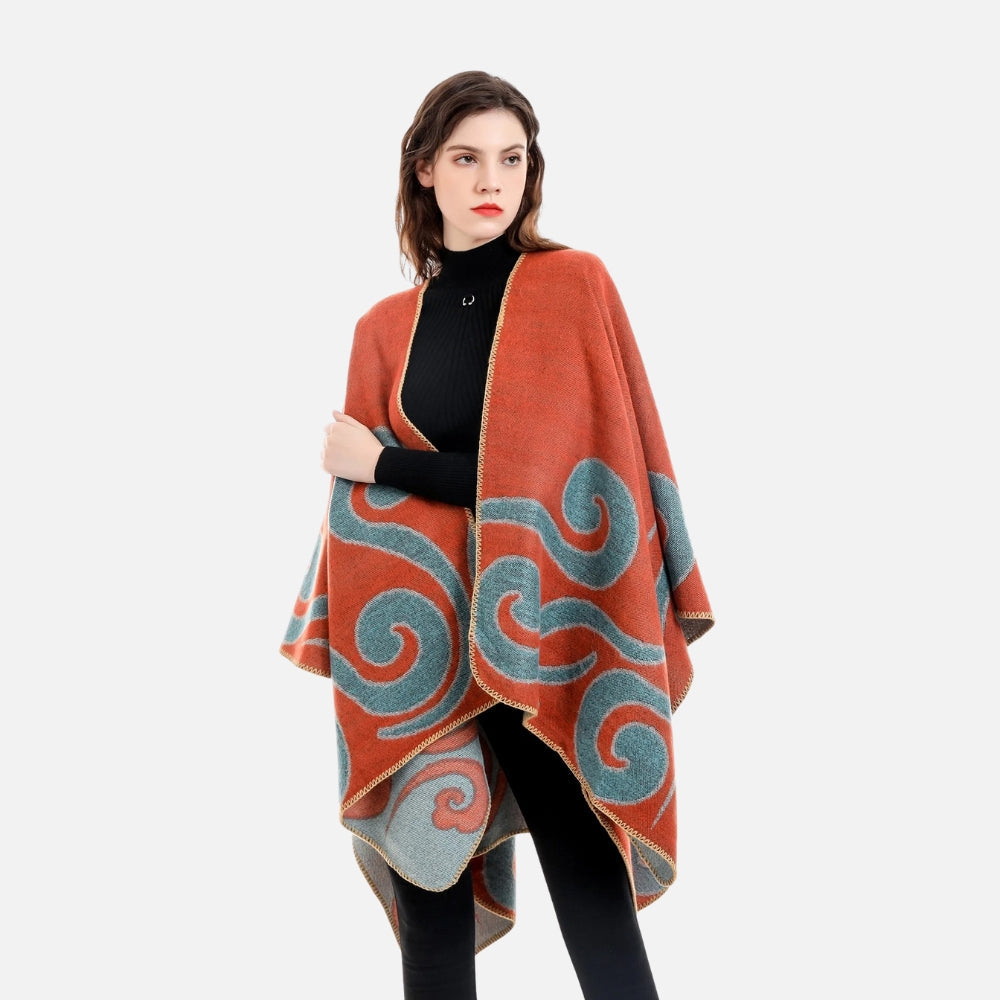 Femme portant cape poncho réversible orange bleu motifs arabesques géométriques vue de face