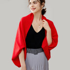 Femme portant une cape poncho laine rouge fluide avec col côtelé sur top noir et jupe grise