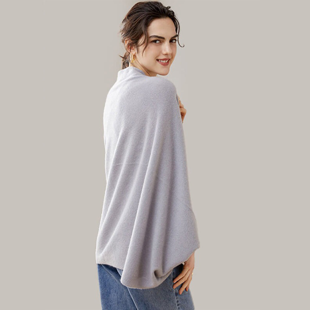 Femme portant une cape poncho en laine grise, bords côtelés, vue de dos, coupe fluide
