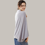 Femme portant une cape poncho en laine grise, bords côtelés, vue de dos, coupe fluide