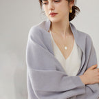 Femme portant cape poncho laine grise bords côtelés, collier or, vue de face