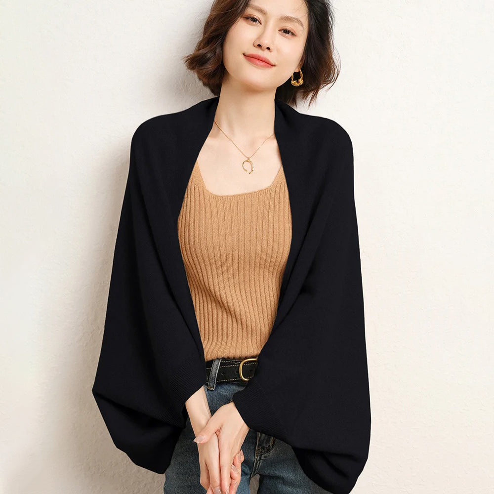 Femme portant cape poncho laine noire fluide sur top camel côtelé et jean