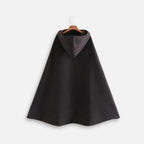 Cape poncho noire longue avec capuche intégrée grise, coupe ample, suspendue sur cintre