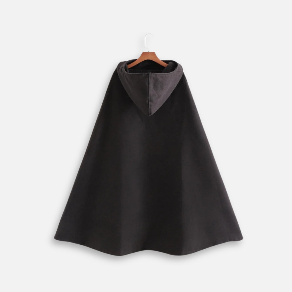 Cape poncho noire longue avec capuche intégrée grise, coupe ample, suspendue sur cintre