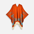 Cape poncho péruvien orange à motifs ailes turquoise, franges crème, col V ouvert