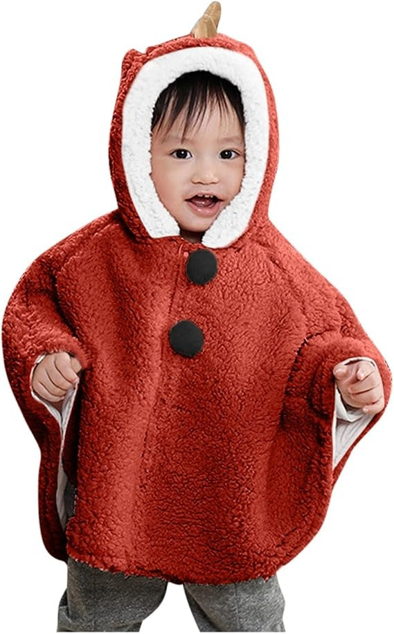 Bébé souriant portant cape poncho polaire rouge avec capuche dinosaure et boutons pression noirs