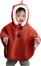 Bébé souriant portant cape poncho polaire rouge avec capuche dinosaure et boutons pression noirs