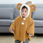 Bébé portant une cape poncho polaire beige avec capuche oreilles et pompons blancs