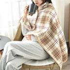 Femme portant cape poncho polaire beige à carreaux avec col montant et boutons pression, tenant tasse