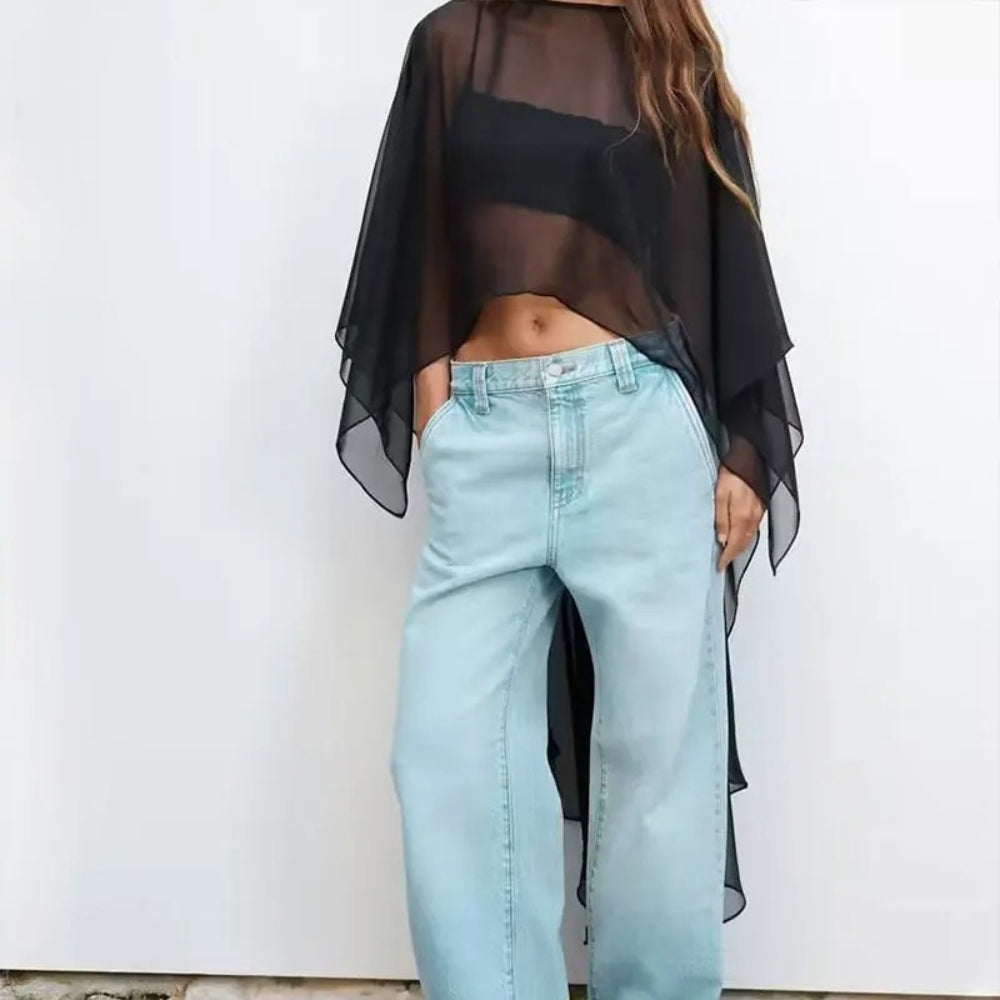Cape poncho voile transparent noir femme porté avec jean clair, vue de face sans manches
