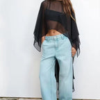 Cape poncho voile transparent noir femme porté avec jean clair, vue de face sans manches