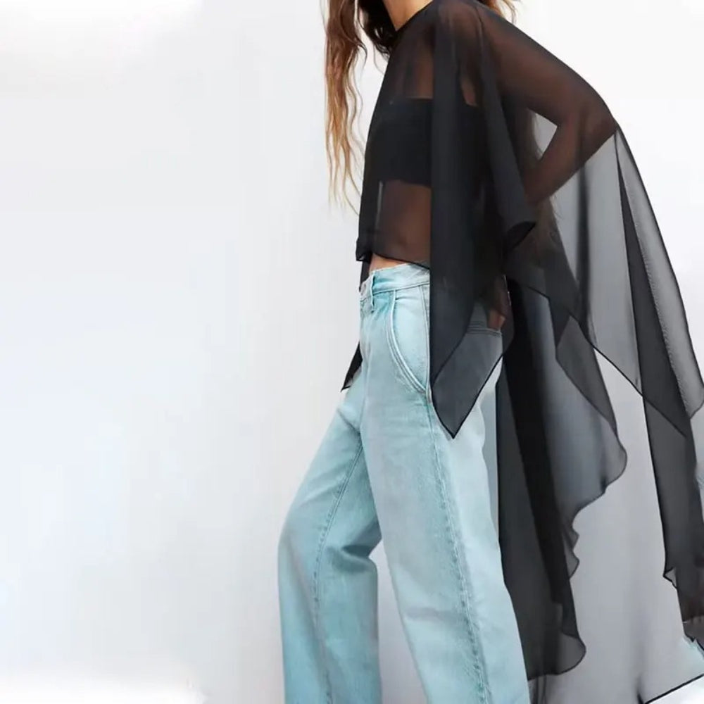 Cape poncho voile noir transparent femme porté avec jean clair, vue de profil