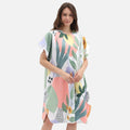 Femme portant poncho de bain blanc à capuche avec motif floral coloré de plantes et feuilles