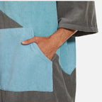 Homme portant poncho de bain microfibre bicolore bleu turquoise et gris avec capuche et manches courtes