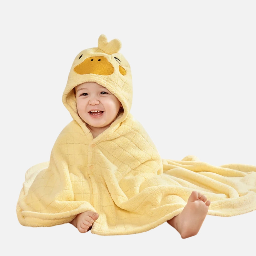 Bébé souriant enveloppé dans un poncho de bain microfibre jaune avec capuche canard