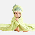 Bébé enveloppé dans un poncho de bain microfibre vert avec capuche dinosaure colorée