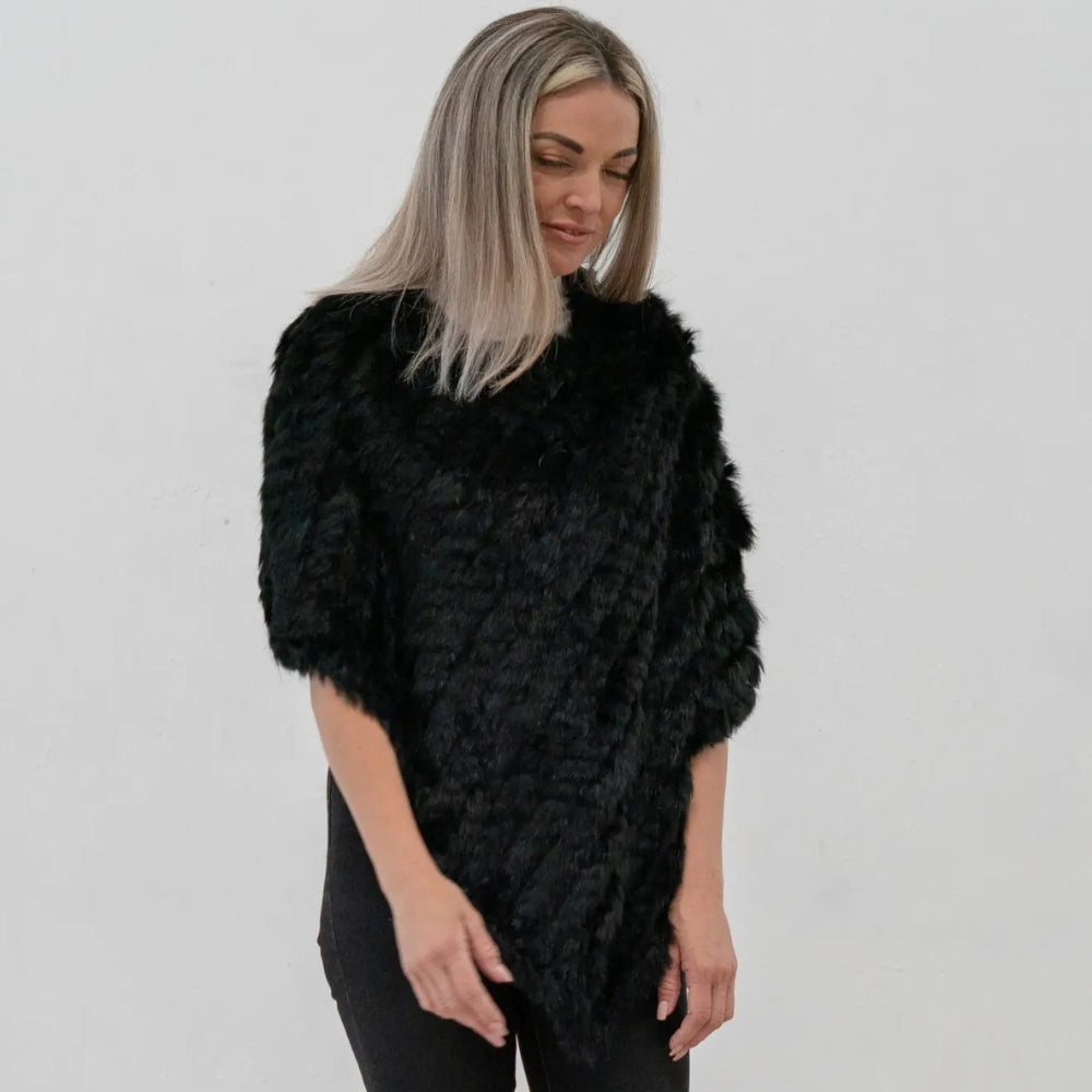 Femme portant un poncho asymétrique en fourrure de lapin noir avec col montant