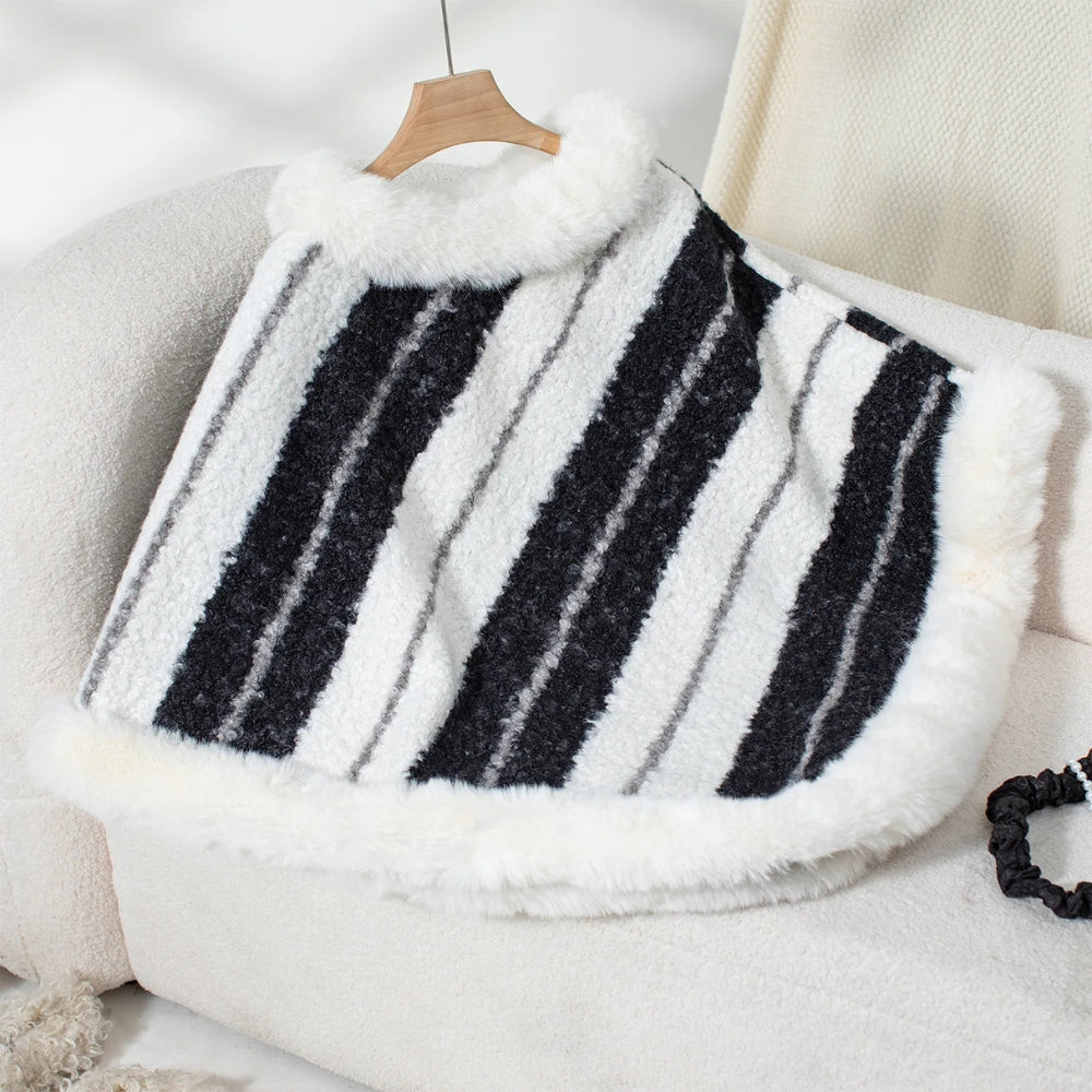 Poncho femme col roulé rayures noires blanches grises, présenté sur chaise écrue