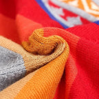 Poncho péruvien femme replié montrant rayures multicolores, franges et col V détaillé