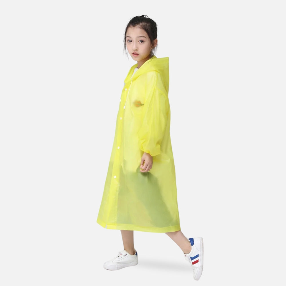 Jeune fille portant un poncho de pluie jaune avec capuche et boutons pression