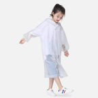 Enfant portant un poncho de pluie blanc transparent avec capuche et boutons pression