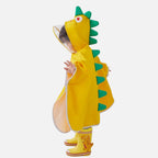 Enfant portant un poncho pluie jaune avec capuche dinosaure verte et bottes assorties