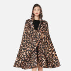 Femme portant un poncho pluie léopard marron noir zippé avec capuche