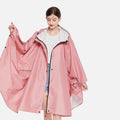 Femme portant poncho pluie rose polyester capuche zip pressions vue de face