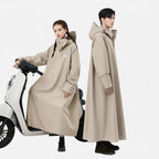 Poncho pluie beige avec capuche porté par deux personnes près d'un scooter blanc