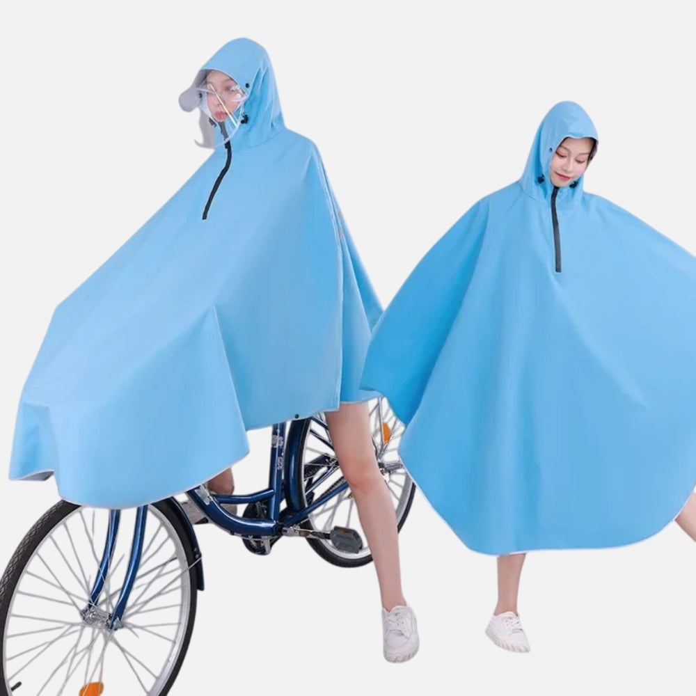 Deux femmes portent un poncho pluie bleu avec capuche et visière, l'une à vélo