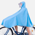 Femme portant poncho pluie bleu vélo avec capuche et visière sur bicyclette