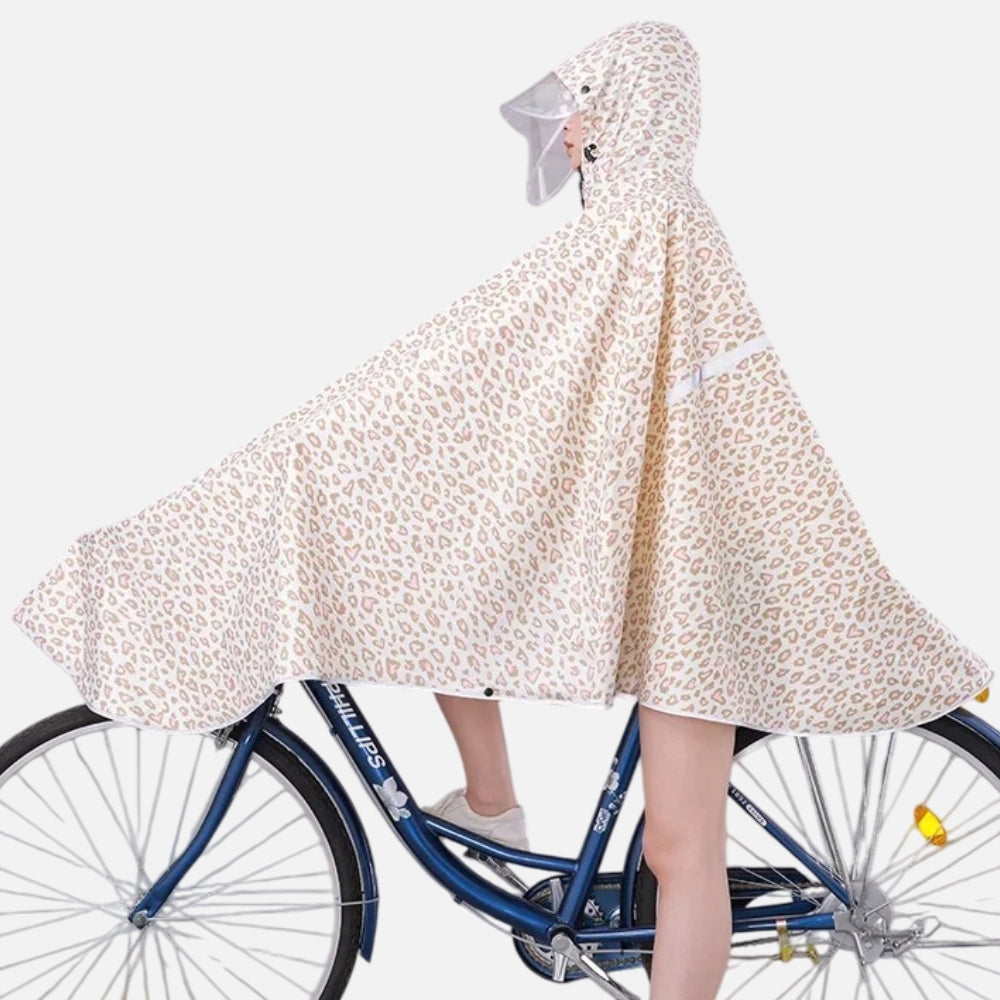 Femme à vélo portant poncho pluie léopard blanc avec capuche et visière grise