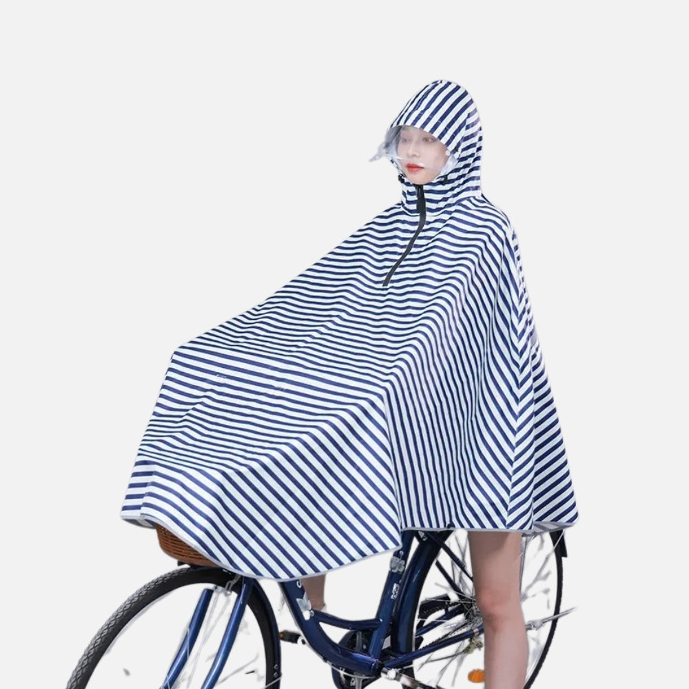 Femme portant poncho pluie marinière bleu blanc à capuche sur vélo de profil
