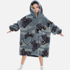 Enfant portant poncho polaire gris capuche motif panthères noires dorées poches