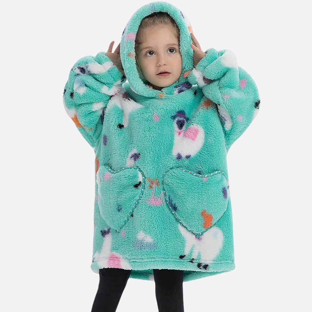 Petite fille portant poncho polaire turquoise à capuche avec motif lamas colorés et poches