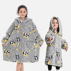 Deux enfants portent un poncho polaire gris à capuche avec motifs pandas et lunes jaunes, poches cœur