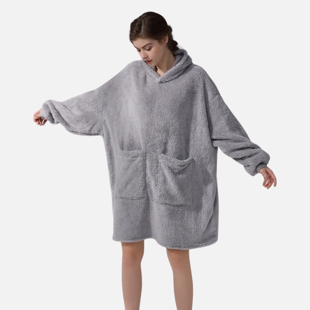 Femme portant un poncho polaire gris avec capuche et poches, manches longues