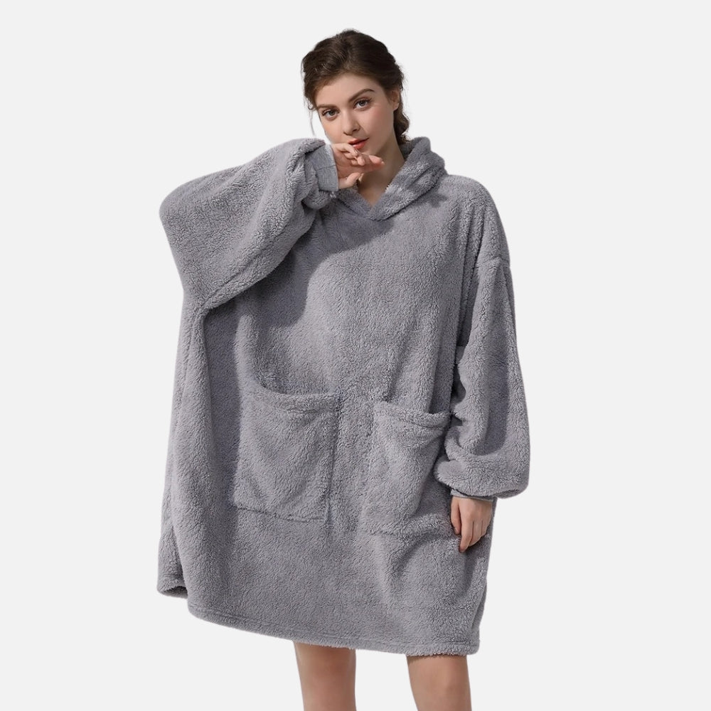 Femme portant un poncho polaire gris à capuche avec manches longues et poche ventrale